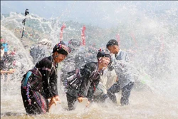 当地居民和游客沉浸在南木溪流中，共同参加泼水节。阮莺摄